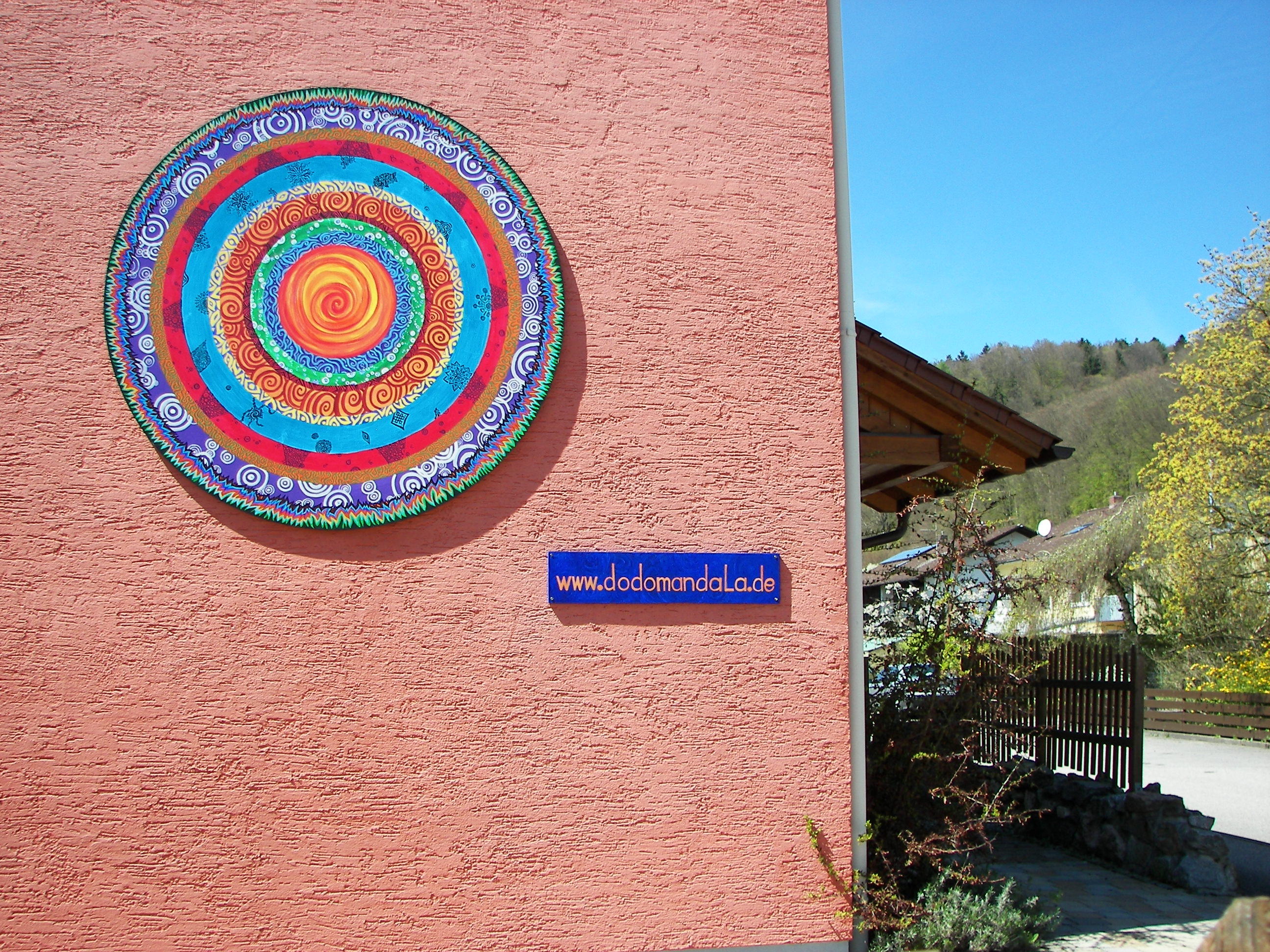 "Siamo Arrivati": Mandala an einer Hausmauer; Acryl auf Betonschalungsplatte, 205 cm Durchmesser